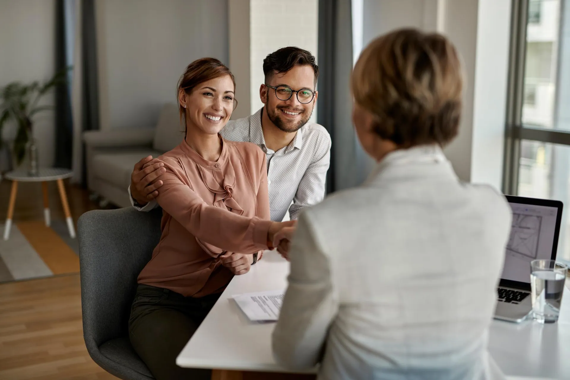 Un couple souriant échange avec une conseillère